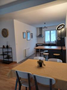 Appartement tout confort - Idéal pour les familles في فوجير: غرفة طعام ومطبخ مع طاولة وكراسي