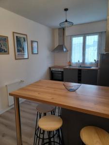 Appartement tout confort - Idéal pour les familles في فوجير: مطبخ مع طاولة خشبية و كرسيين +11 صورة