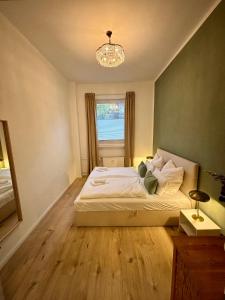 1 dormitorio con 1 cama con ventana y lámpara de araña en EasyPark City Suite, en Brunswick