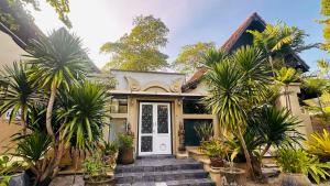 une maison avec des palmiers devant dans l'établissement Montra Resort, à Nathon Bay