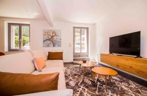 a living room with a white couch and a flat screen tv at Mystras 2 Residences Upper and Ground Floor in Mystras