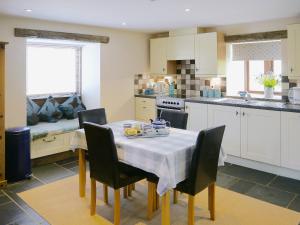a kitchen with a table and chairs and a kitchen with a table andktop at Bramble in Hartland