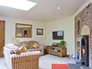 ein Wohnzimmer mit zwei Sofas und einem Kamin in der Unterkunft Old Stones in Glendevon