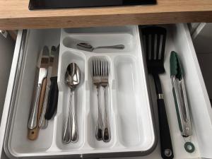 a white tray with utensils in a drawer at Bellavista Home in Trimbach
