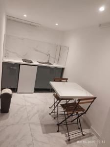 eine Küche mit Tisch und Stühlen in einem Zimmer in der Unterkunft Studio à Eckbolsheim proche CV et marché de Noël de Strasbourg in Eckbolsheim
