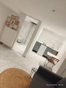 ein weißes Wohnzimmer mit einem Tisch und einem Stuhl in der Unterkunft Studio à Eckbolsheim proche CV et marché de Noël de Strasbourg in Eckbolsheim