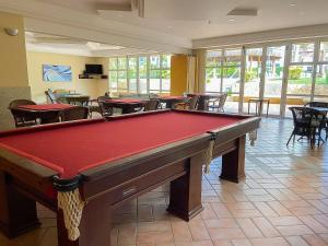 a pool table in a room with tables and chairs at Riviera | Aconchegante e Charmoso - Enxoval Compl in Riviera de São Lourenço