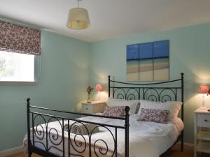 a bedroom with a black bed with two lamps at Fairlaw Garden Cottage in Reston