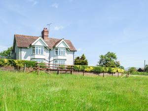 een wit huis met een hek in een veld bij Barnleigh in Ludlow