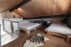 une chambre mansardée avec deux lits et un échiquier dans l'établissement Appartement au cœur des montagnes, à Métabief