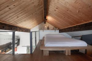 une chambre avec un lit et un plafond en bois dans l'établissement Appartement au cœur des montagnes, à Métabief