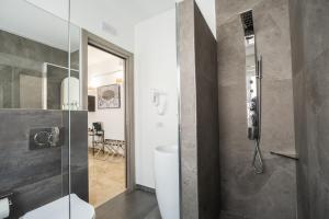 a bathroom with a toilet and a glass shower at Talìa Rooms And Gallery in Messina