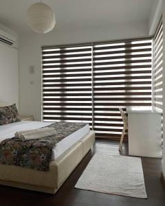 Un dormitorio con una cama y una ventana grande en Rix Palm Apartments, en Kyrenia