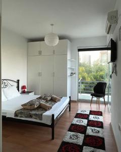 Un dormitorio con una cama, una silla y una ventana en Rix Palm Apartments, en Kyrenia