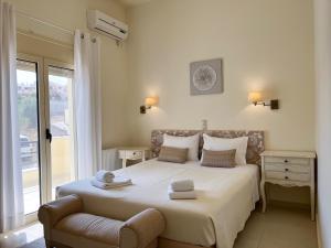 a bedroom with a bed with a chair and a window at Sea Breeze - Home with a View in Bouzéïka