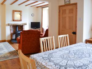 a dining room with a table and chairs and a living room at Gunluk Cottage in Brompton