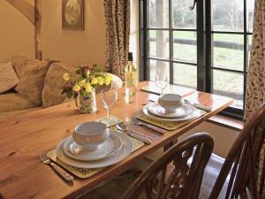 a wooden table with plates and wine glasses on it at Robins Nest - 29409 in Elmsted