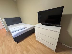 a small bedroom with a tv and a dresser with a bed at Park View Apart in Kouvola