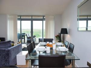 a living room with a glass table and chairs at Fistral View - 3 Cribbar in Newquay