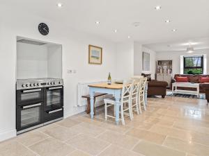 a kitchen and living room with a table and a stove at Morfa Ganol in Llangranog