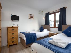 a hotel room with two beds and a television at Coot in Wroxham
