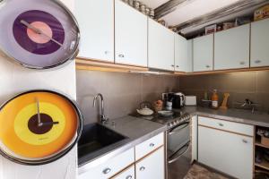 une cuisine avec un évier et une horloge murale dans l'établissement Appartement au cœur des montagnes, à Métabief 12 autres photos