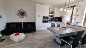 a kitchen and living room with a table and a couch at Sole del Garda 10 in Lazise