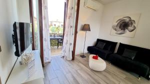 a living room with a couch and a television at Sole del Garda 10 in Lazise