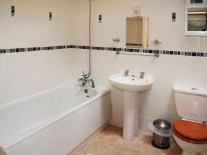 a bathroom with a sink and a tub and a toilet at Serendipity in Keswick +3 photos