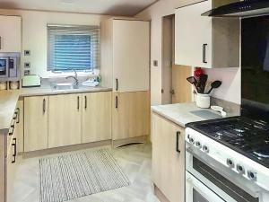 a kitchen with white cabinets and a stove top oven at Graylings Rest - Uk35759 in Brigham