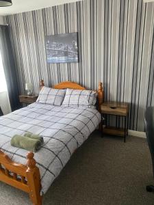 a bedroom with a bed with a checkered blanket at Spacious Property For Hols Base & Contractors Long or Short Stays C2C Western Lakes in Cleator Moor