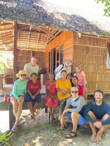 een groep mensen die voor een hut zitten bij Bruno Raja Ampat Homestay in Pulau Mansuar