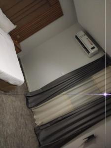 Una cama en una habitación de hotel con un control remoto en شقق رفاء, en Al Ula