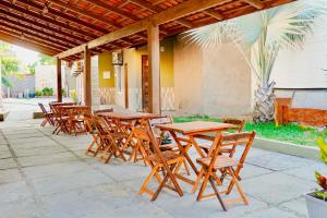 a group of wooden tables and chairs on a patio at Pousada Residência Lençóis in Barreirinhas