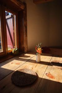 a room with a wooden floor with a vase of flowers at Leśna Kopuła in Krempna