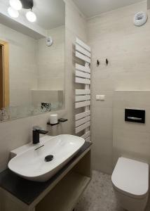 a bathroom with a white sink and a toilet at Bella Monte in Szczyrk