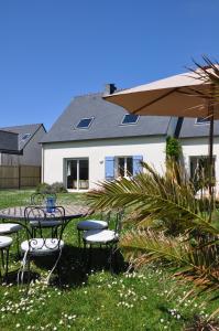 a patio with tables and chairs in front of a house at Maison d'Aude in Brignogan-Plage
