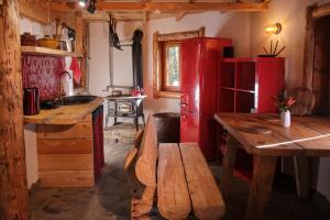 a kitchen with a wooden table and a red refrigerator at Leśna Kopuła in Krempna