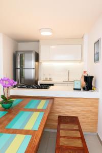 a kitchen with a counter with a colorful rug at Vista Serra e Mar in Bertioga