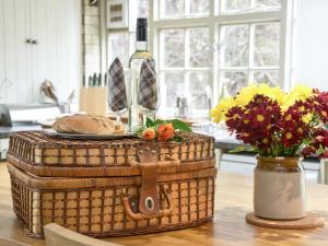 a table with a basket with a bottle of wine and flowers at Greenlands Farmhouse in Barmby on the Moor