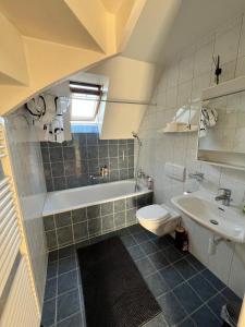 Un baño con bañera, inodoro y lavabo. en Charmettes, en Neuchâtel