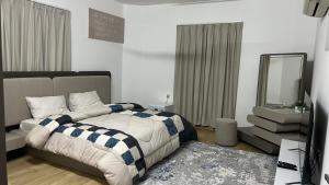 a bedroom with a bed with a mirror and a rug at المسارات الدولية in Mawāliḩ