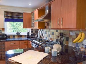 eine Küche mit Holzschränken und Bananen auf der Theke in der Unterkunft Treetops in Bowness-on-Windermere