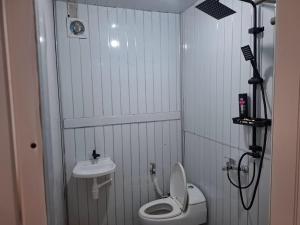 a small bathroom with a toilet and a sink at Hillside guest house and restaurant in Gitgit