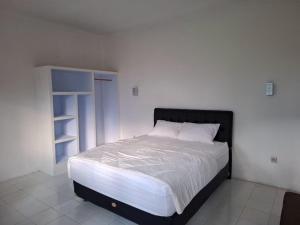 a bedroom with a large bed and a book shelf at Hillside guest house and restaurant in Gitgit +4 photos