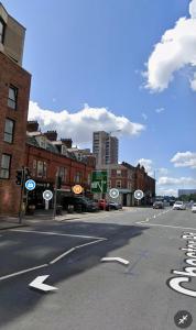 an empty city street with traffic signs and buildings at Chic & Modern 2BR Apartment - Luxury Manchester Retreat in Manchester