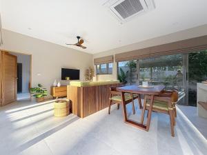 een woonkamer met een houten tafel en een televisie bij Villa Souimanga 2Bed Balinese style Garden & Pool in Mae Nam