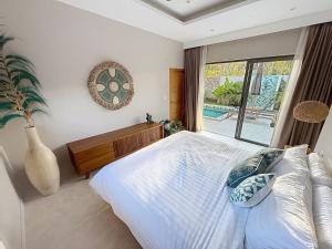 een slaapkamer met een bed en een vaas bij Villa Souimanga 2Bed Balinese style Garden & Pool in Mae Nam +18 foto's