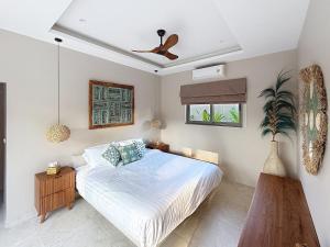 een slaapkamer met een bed en een plafondventilator bij Villa Souimanga 2Bed Balinese style Garden & Pool in Mae Nam