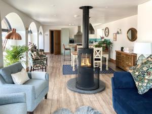 a living room with a fireplace in the middle at The Cart House in Duns